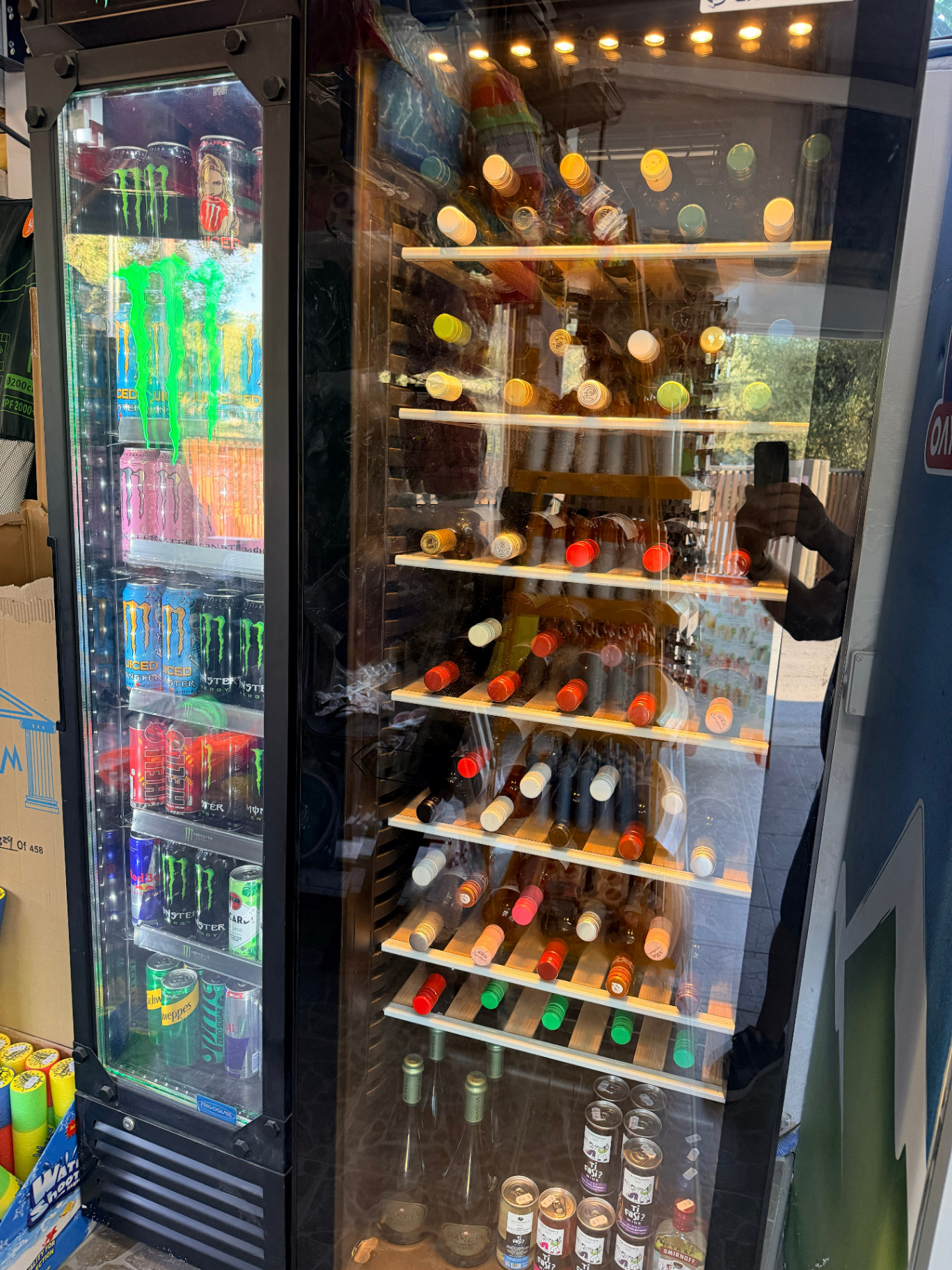 Wine cellar with Greek and Cretan wines next to energy drinks fridge at AMOS SEASIDE Mini Market Marathi Chania Crete